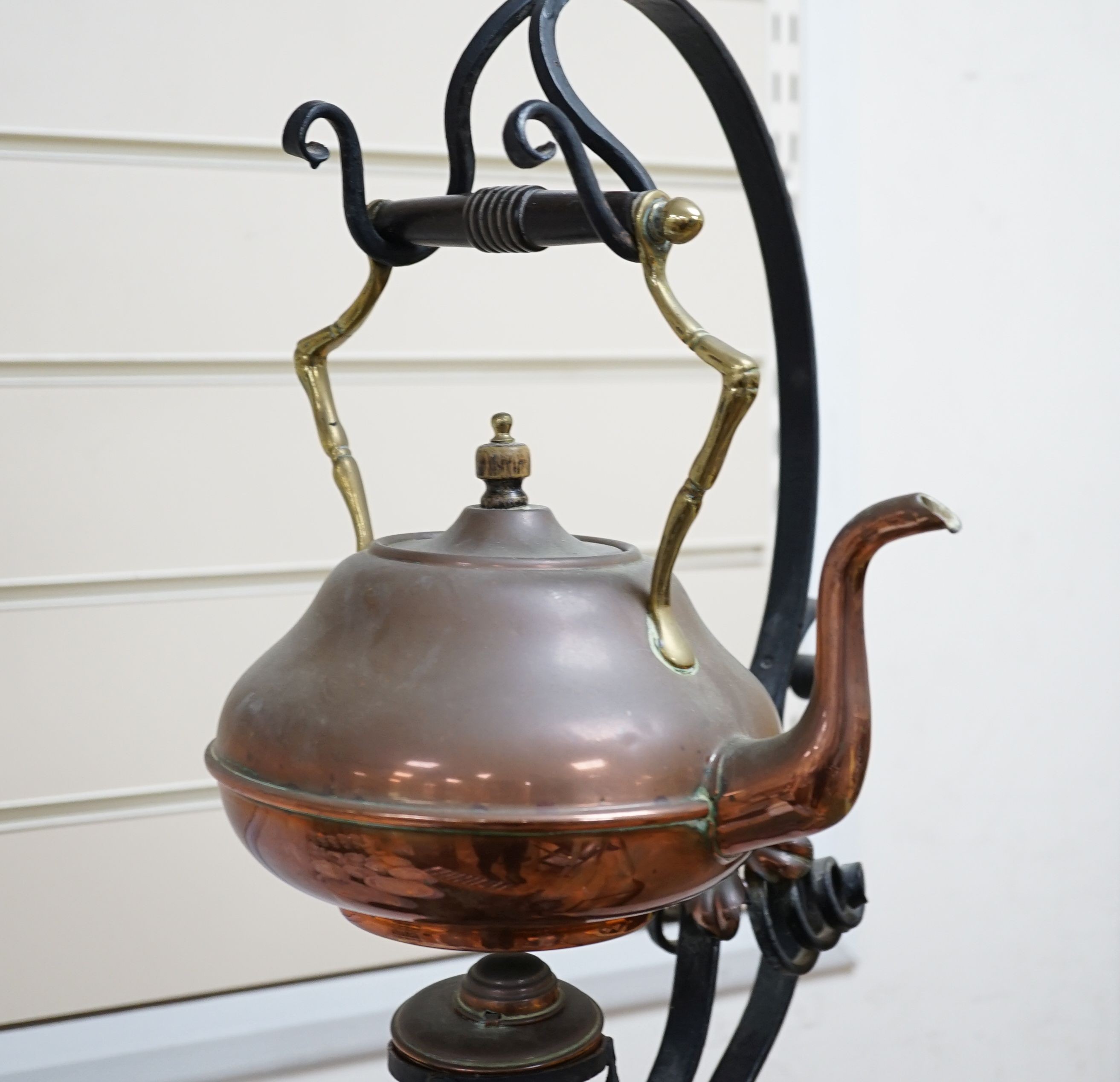 An Arts & Crafts wrought iron and copper burner stand with associated copper kettle 83cm